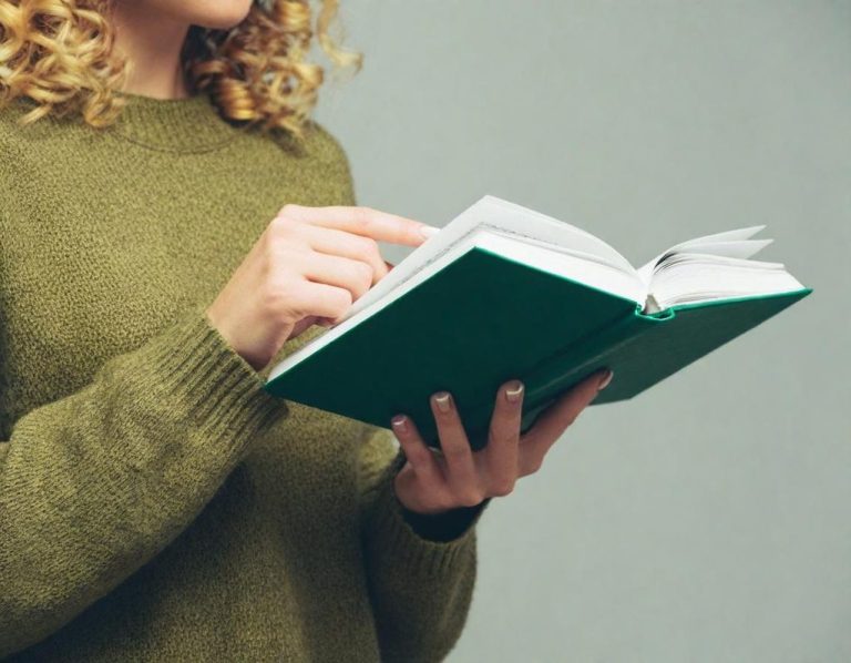 Mujer con suéter verde sosteniendo un libro abierto, señalando una página.